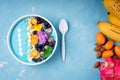 Smoothie bowl with fruits, berries, nuts and flowers. Tropical healthy smoothie dessert. Healthy breakfast, vegetarian, dieting Royalty Free Stock Photo