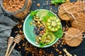 Smoothie bowl with green spirulina, kiwi, mint and pumpkin seeds. Breakfast. Top view.