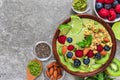 Smoothie bowl made of matcha green tea with fresh fruits, berries, nuts, seeds with a spoon for healthy diet breakfast Royalty Free Stock Photo