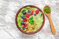Smoothie bowl made of matcha green tea with fresh fruits, berries, nuts, seeds with a spoon Royalty Free Stock Photo