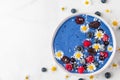 Smoothie bowl or nice cream made of blue spirulina, frozen berries, banana and coconut with chamomile flowers Royalty Free Stock Photo