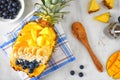 Smoothie bowl in a pineapple with coconut, bananas, mango & blueberries, above view scene Royalty Free Stock Photo