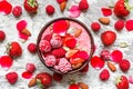 Smoothie bowl with red berries - strawberry and frozen raspberry, nuts, seeds and rose flowers petals Royalty Free Stock Photo