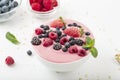 Smoothie bowl with yogurt, muesli and frozen berry. Pink yogurt smoothie bowl topped with frozen berries. Royalty Free Stock Photo