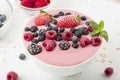 Smoothie bowl with yogurt, muesli and frozen berry. Pink yogurt smoothie bowl topped with frozen berries. Royalty Free Stock Photo