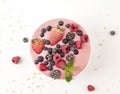 Smoothie bowl with yogurt, muesli and frozen berry. Pink yogurt smoothie bowl topped with frozen berries.