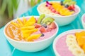 smoothie bowls garnished with fresh tropical fruit slices on a bright caf table