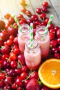 Smoothie cocktails on a red berries and fruits background