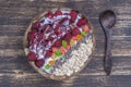 Smoothie in coconut bowl with raspberries, oatmeal, candied fruit and chia seeds for breakfast , close up. The concept of healthy Royalty Free Stock Photo