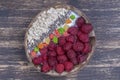 Smoothie in coconut bowl with raspberries, oatmeal, candied fruit and chia seeds for breakfast , close up. The concept of healthy Royalty Free Stock Photo