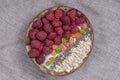 Smoothie in coconut bowl with raspberries, oatmeal, candied fruit and chia seeds for breakfast , close up. The concept of healthy Royalty Free Stock Photo