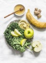 Smoothie detox drink ingredients - kale, apple, banana, honey, ginger, lemon on a light background, top view