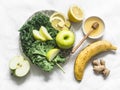 Smoothie detox drink ingredients - kale, apple, banana, honey, ginger, lemon on a light background, top view