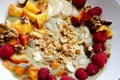 Smoothie fruit bowl with banana, peaches, raspberries, nuts, granola and pumpkin seeds for breakfast. Tasty oatmeal with fruits in Royalty Free Stock Photo