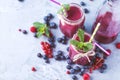 Flat-lay of colorful smoothies in bottles with tropical fruit and superfoods on concrete background Royalty Free Stock Photo