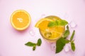 Smoothie with orange on a pink table. Decorated with mint, ice