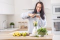 Smoothie preparation by cutting bananas into a blender by a woman in a sweater at home Royalty Free Stock Photo