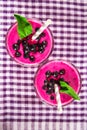 Smoothies of black currant in glass glasses with straws on a white wooden table. Top view. Royalty Free Stock Photo