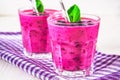 Smoothies of black currant in glass glasses with straws on a white wooden table. Royalty Free Stock Photo
