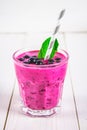 Smoothies of black currant in glass glasses with straws on a white wooden table. Royalty Free Stock Photo