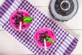 Smoothies of black currant in glass glasses with straws on a white wooden table. Top view. Royalty Free Stock Photo