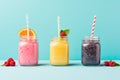 Smoothies in glass jars with straws on blue background, Fresh fruit smoothies in glass jars with straws on blue background, AI Royalty Free Stock Photo