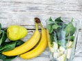 Healthy food. Smoothies and ingredients for detox, banana, pear, spinach leaves on a gray wooden background, top view, copy space