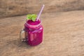 Smoothies of a red organic dragon fruit on an old wooden background