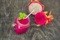 Smoothies of a red organic dragon fruit on an old wooden background