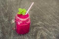 Smoothies of a red organic dragon fruit on an old wooden background