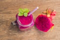Smoothies of a red organic dragon fruit on an old wooden background