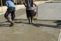 Smoothing concrete with vibrating screed machine