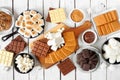 Smores buffet table scene. Roasted marshmallows, crackers, chocolate and a selection of ingredients. Top view over a white wood Royalty Free Stock Photo