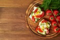 Smorrebrod - traditional Danish sandwiches. Black rye bread with boiled egg, cream cheese, cucumber, tomatoes on dark brown wooden