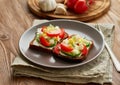 Smorrebrod - traditional Danish sandwiches. Black rye bread with boiled egg, cream cheese, cucumber, tomatoes on dark brown wooden