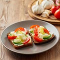 Smorrebrod - traditional Danish sandwiches. Black rye bread with boiled egg, cream cheese, cucumber, tomatoes on dark brown wooden