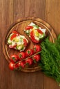 Smorrebrod - traditional Danish sandwiches. Black rye bread with boiled egg, cream cheese, cucumber, tomatoes on dark brown wooden