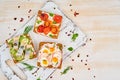 Smorrebrod - traditional Danish sandwiches. Black rye bread with herring, egg, tomatoes, radish on white wooden table, top view