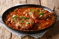 smothered beef steak cooked in tomato sauce with vegetables close-up. Horizontal