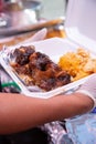 smothered oxtail, soul food, styrofoam container, hand, glove