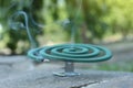 Smouldering insect repellent coil on stone outdoors