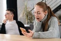SMS. Closeup portrait funny shocked anxious scared young girl looking at phone seeing bad news photos message with