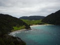 Smugglers Bay beach with lush green grass nature landscape seen from Busby Head Whangarei Heads Northland New Zealand