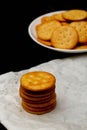 Snack concept, Salty crackers or biscuits arranged in vertical row on paper and heap on white plate