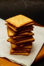 Snack concept, Salty crackers or biscuits arranged in vertical row on paper and saucer wooden