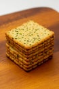 Snack concept, Vegetable crackers or biscuit arranged in vertical row on wooden saucer