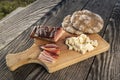 Snack with delicious South Tyrolean smoked bacon and cheese with flat bread lying on a rustic table Royalty Free Stock Photo