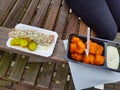 Snack on a Dutch wooden bench with fresh herring with onions and cucumbers and fried cod patties Royalty Free Stock Photo