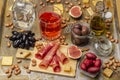 Snack food. Jamon and figs on board. Olives in glass jars. Glass of rose wine and sprig of grapes