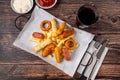 Snack plate with french fries, crispy chicken, cheese sticks, sausage and spring rolls on wooden table Royalty Free Stock Photo